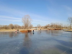 People skating in a park / People playing on the ice in a park. I feel the warmth of winter, a stable society, and the happiness of harmonious family. That's what I want as well.