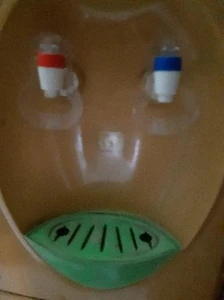 A dispenser / I'm drinking water from the dispenser and it makes me healthy.