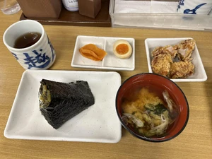 Lunch eaten around 11:30 A.M. I dined with a friend. I ate an onigiri rice ball, miso soup, and fried chicken. This was purchased at a restaurant.