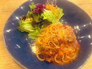 I ate a red sauce spaghetti with ground meat and dined with a friend.