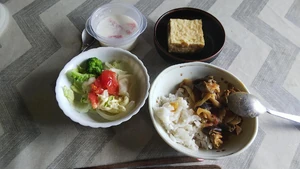 Lunch eaten in August 2023, around 11:30 A.M. I ate by myself at my home. I prepared this meal. It was a rare instance where my family wasn't home around lunch, so I prepared a menu of foods they don't enjoy eating. I browsed my smartphone as I ate. I had tomato curry, a steamed veggie salad, fried soft tofu, and milk agar jelly.