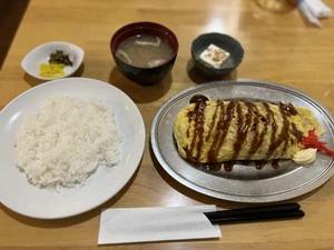 Lunch eaten on January 15, 2024, around 2:00 P.M. I ate with an older friend, and we chatted as we ate. I had the omurice soba noodle set meal. The meal was prepared by a restaurant employee and eaten somewhere in Osaka.