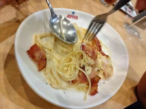 Dinner eaten five days ago around 7:00 P.M. I took this photo at a restaurant in a department store. I ate it with my family. The photo is of us eating. I ate spaghetti. The restaurant was a pasta restaurant.