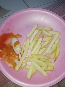 This is a photo of otak-otak (fish cake) and French fries that I am currently eating. The photo was taken to clearly show the quality and ingredients used and it was prepared by a restaurant. I ate it in the evening when the restaurant wasn't busy.