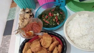 This photo is of lunch in my home three days ago on Friday, January 12, 2024. My mother and I worked together to create a delicious, simple meal for my husband and daughter. We ate warm rice, sambal (chili sauce), dried fish, stir-fried water spinach, and I prepared nuggets for my children.