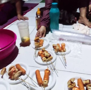 This photo was taken at a New Year's Eve event, and I spent it with my children, my neighbor, and their children. The children had grilled sausages, everyone had tom yum kung, and the men prepared grilled fish. We ate dinner at a small cabin located within a park near our house.