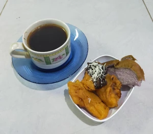 I had a small amount of bread and fried banana with hot black coffee at a friend's house while we relaxed.